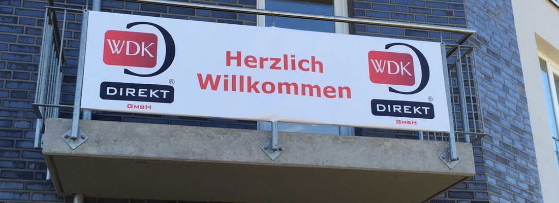 Banner Plane mit Aufdruck „Herzlich Willkommen“ und WDK Direkt GmbH Logo – Werbetechnik Folien Fischer Hamburg Bergedorf, Reinbek, Glinde, Geesthacht, Wentorf und Lauenburg