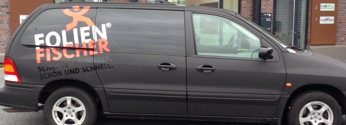 Folien Fischer Hamburg Fahrzeugbeschriftung auf Transporter – schwarzer Firmenwagen mit Logo und Slogan für Werbetechnik, Schilder und Folienarbeiten in Bergedorf, Reinbek, Glinde, Geesthacht und Wentorf