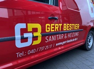 rotes fahrzeug mit folienbeschriftung beklebt in gelb und weiß