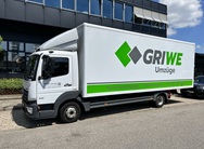 lkw beschriftung  in grau grüner schrift mit einem grünen balken wo schrift eingesetzt wurde